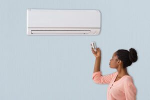lady turning on AC unit