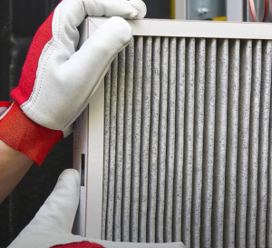 person pulling filter out of ac unit