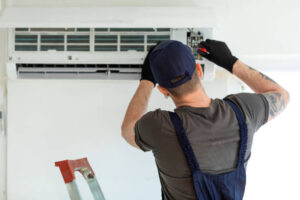 man repairing ac unit