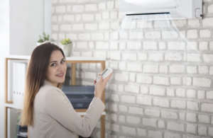 woman turning on AC unit